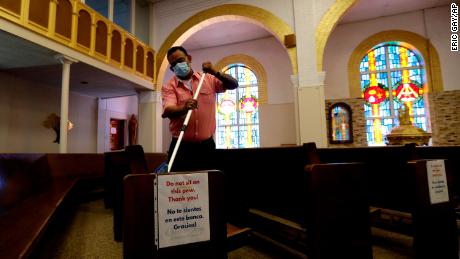 A man helps clean and sanitize pews following an in-person Mass at Christ the King Catholic Church in San Antonio on May 19.